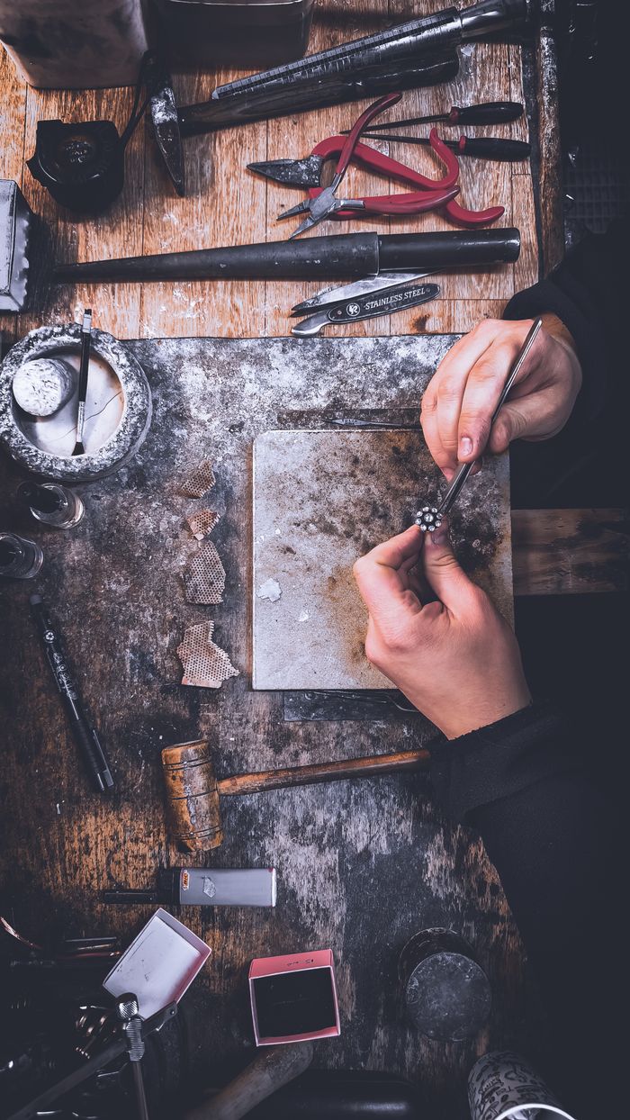 services-img Artisan polishing jewelry on workbench with tools in a workshop in Tekirdağ, Türkiye.